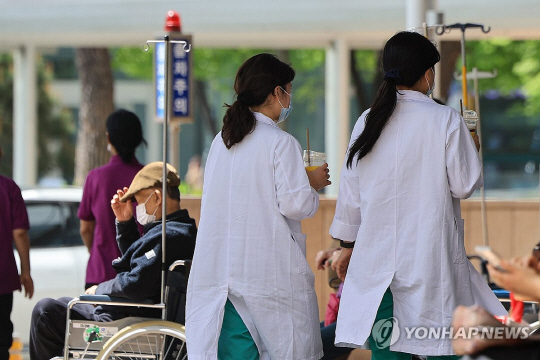 전공의들이 병원을 떠난지 두 달이 흐른 21일 서울 시내 한 대학병원에서 의료진이 이동하고 있다. 연합뉴스